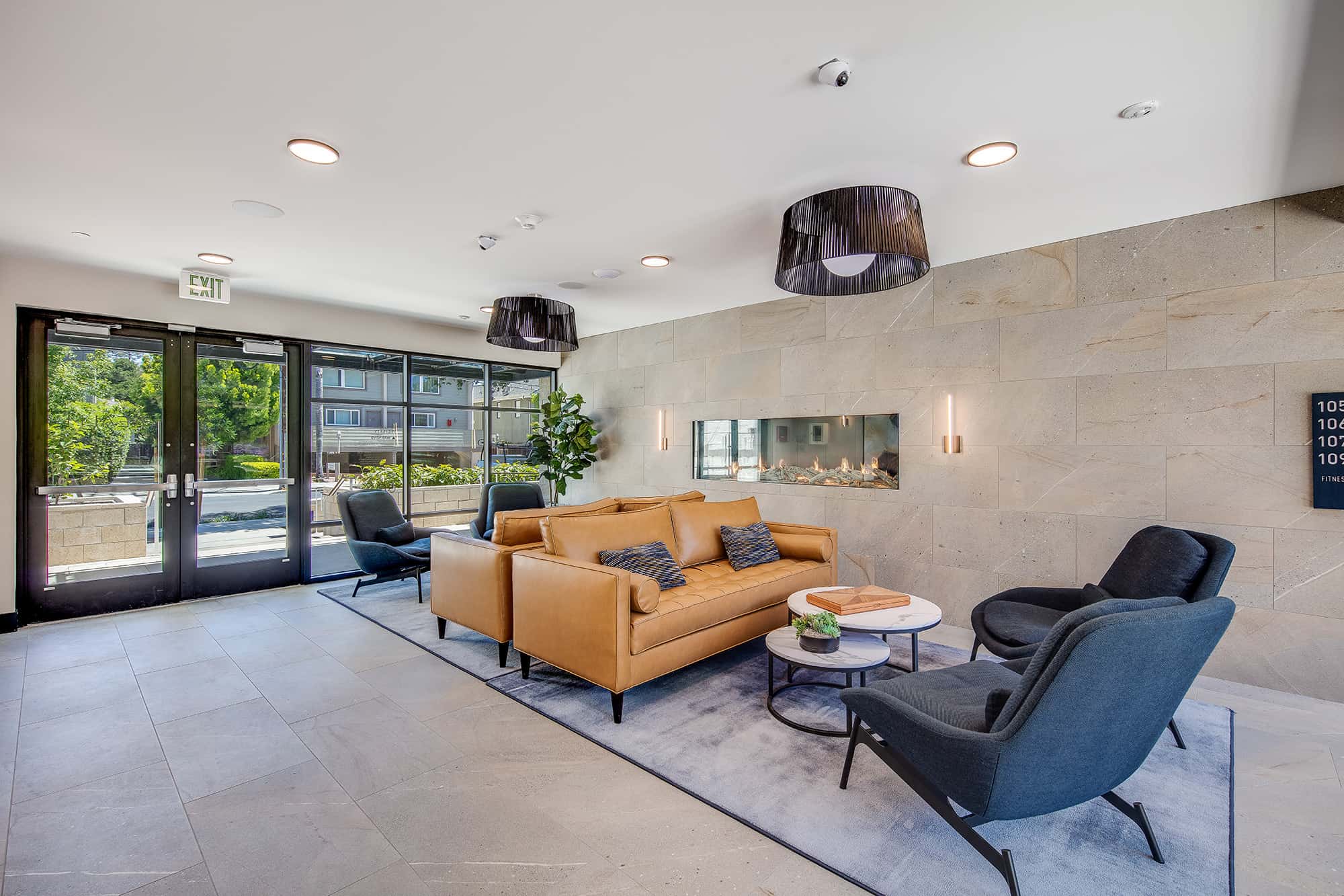 Luxury Apartments in Menlo Park CA - Realm - Private Entry Lounge With Stylish Furniture, a Fireplace, and Floor to Ceiling Windows