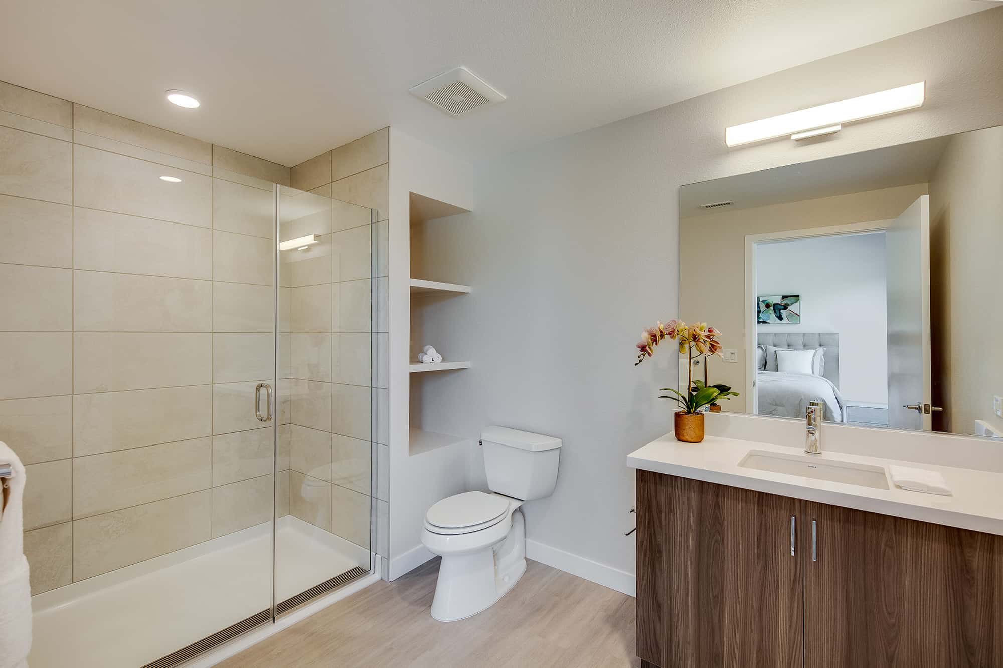 Luxury Apartments Menlo Park - Realm - Spacious Bathroom With a Glass Shower, Large Mirror, Wooden Cabinets, and Shelving
